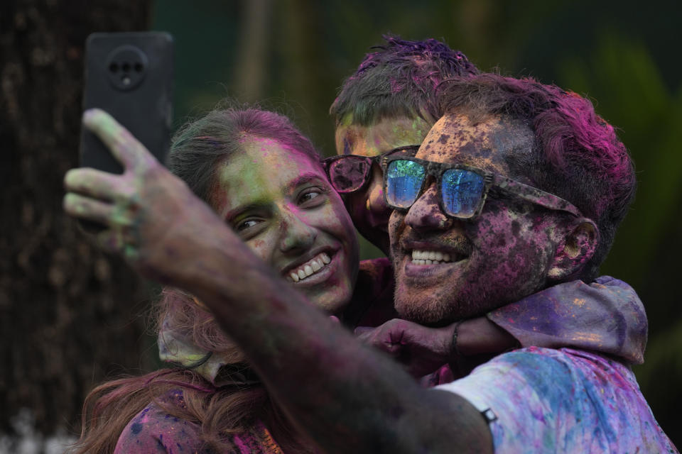 A family takes selfie as they celebrate Holi, the Hindu festival of colors, in Mumbai, India, Monday, March 25, 2024. (AP Photo/Rafiq Maqbool)