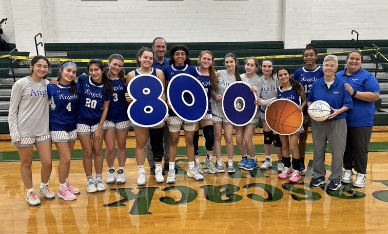 The Holy Angels girls basketball team celebrated coach Sue Liddy's 800th career win by presenting her with a commemorative basketball, following the Angels' 42-28 victory over Cresskill at the Joe Poli Holiday Tournament on Dec. 30, 2023 in Hillsdale.