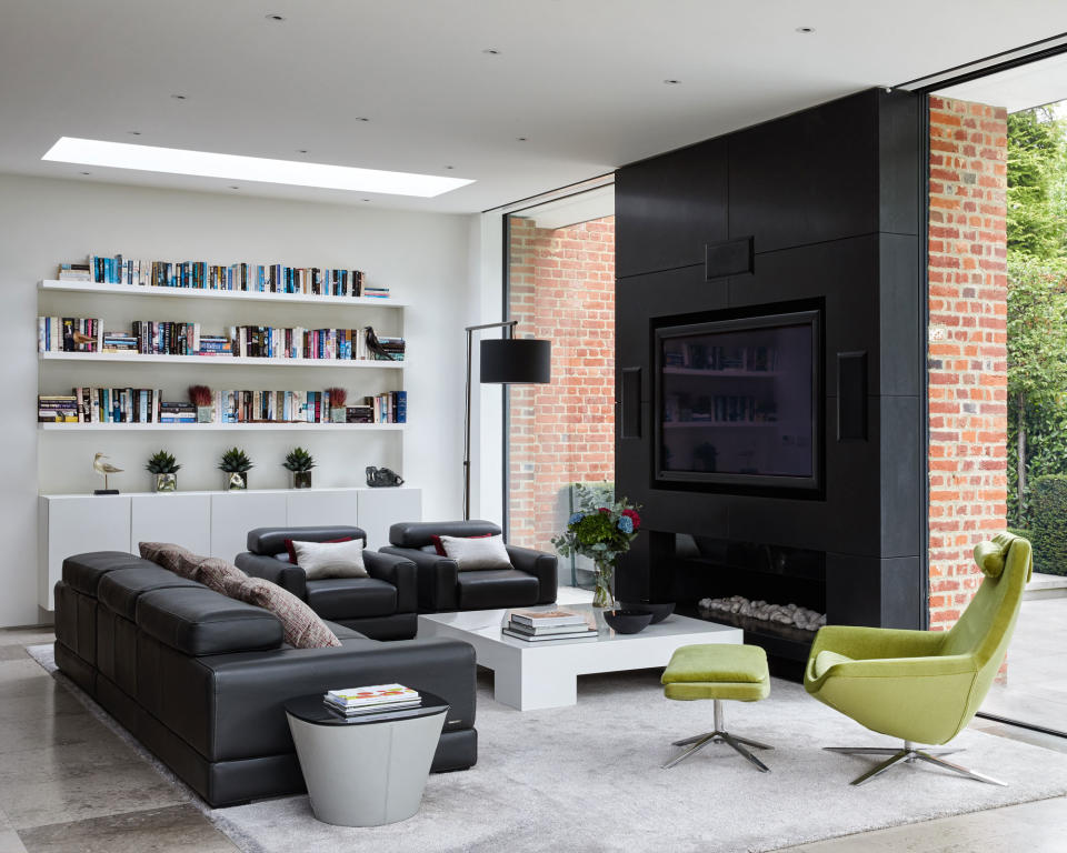 <p> For a more minimal look for your family room ideas with fireplaces, there are many modern fireplace designs available that make this traditional architectural feature into more of a discreet element rather than the main focal point in a room. </p> <p> In this open-plan family room, both the TV and fireplace effortlessly blend into the black painted feature wall &#x2013; a bold and striking design that ironically also works well to hide certain elements in the room. The low fireplace still creates an element of coziness and comfort but in an understated and discreet way &#x2013; a great tip to remember for family room TV ideas if you want your TV to also be a discreet feature in the room. </p>