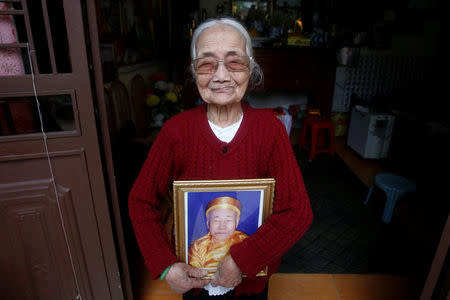 Vietnamese Nguyen Thi Xuan, 94, who married Japanese soldier Nguyen Van Duc during World War Two, poses with a portrait of him at her house in Hanoi, Vietnam February 14, 2017. REUTERS/Kham