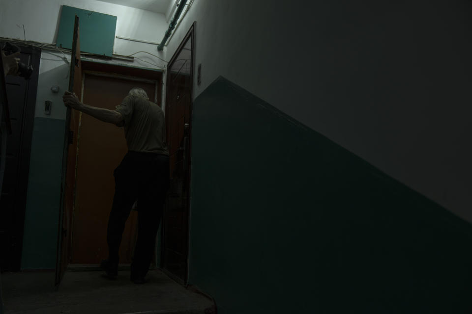 Seventy-year-old pensioner Valerii Ilchenko, who lives alone and is refusing to evacuate, walks to his apartment, after filling out his daily crossword, in Kramatorsk, eastern Ukraine, Wednesday, July 6, 2022. Now a widower, Ilchenko says he still has no intention of leaving. "I don't have anywhere to go and don't want to either. What would I do there? Here at least I can sit on the bench, I can watch TV," he says in an interview in his single-room apartment. (AP Photo/Nariman El-Mofty)