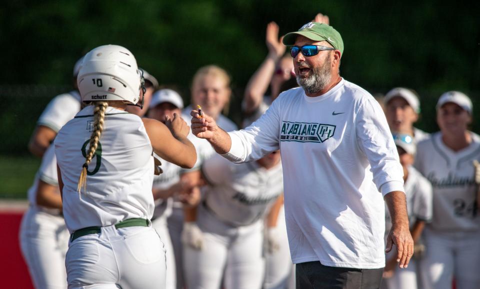 Pendleton Heights High School head coach Rob Davis hands a piece of candy to senior Bo Shelton (9) as she rounds the bases after hitting a home run during a IHSAA Class 4A Softball Sectional Championship game against New Palestine High School, Thursday, May 25, 2023, at New Palestine High School.