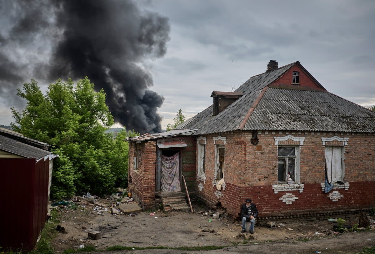 Smoke rises above a damaged building after shelling, on the outskirts of Kharkiv (EPA)
