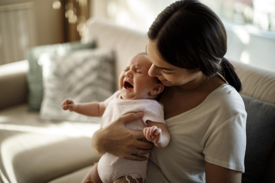 Newborn baby crying in mother hands