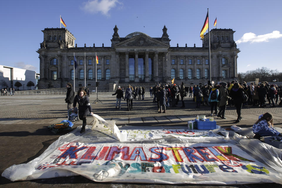 Una mujer prepara una gran pancarta con la leyenda "Huelga por el clima" durante la movilización "Juventud por el Clima", frente al parlamento en Berlín, viernes 18 de enero de 2019. (AP Foto/Markus Schreiber)