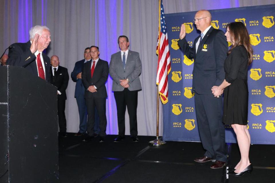 Fellsmere Mayor Joel Tyson, left,  swears in Police Chief Keith Touchberry, with his wife, Kimberly, beside him,  as president of the Florida Police Chiefs Association in August 2022 at the association’s 70th Summer Training Conference in Palm Beach Gardens.