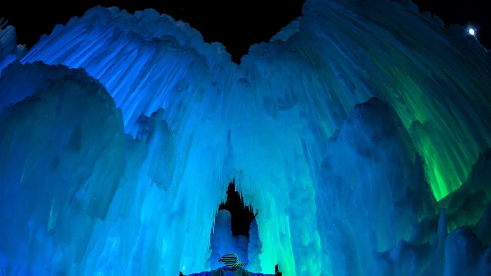 a person standing in a large ice cave