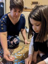 In this photo provided by Christina Neu, Christina Neu works on a puzzle with her six-year-old daughter Charissa Wednesday, June 9, 2021, in Wichita, Kan. Neu didn't enroll Charissa in kindergarten last fall even though she would have been one of the older kids in her class because of concerns about the pandemic. (Christina Neu via AP)