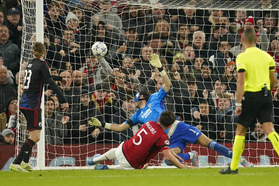 Harry Maguire, del Manchester United, se desliza para anotar ante el Copenhague en un partido de la Liga de Campeones, disputado el martes 24 de octubre de 2023 (AP Foto/Dave Thompson)