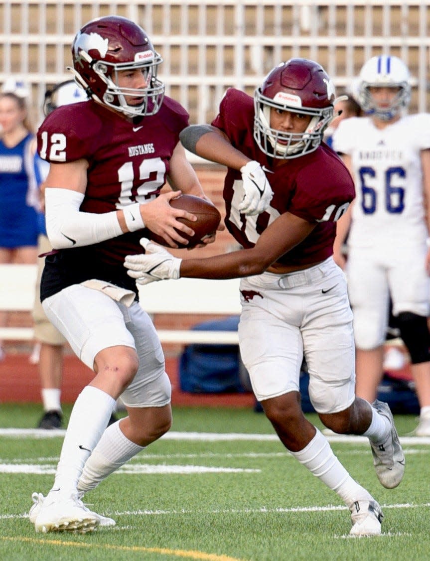 Salina Central's Parker Kavanaugh (12) fakes a handoff to Kenyon McMillan during a 2021 game against Andover at Salina Stadium.