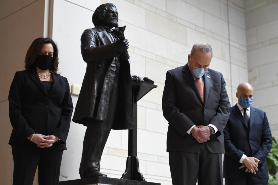 Standing near a statue of Frederick Douglass, Senator Kamala Harris, left, Senate Minority Leader Chuck Schumer, centre, and Senator Cory Booker, right, pause during a prayer on Capitol Hill on Thursday: AP Photo/Susan Walsh