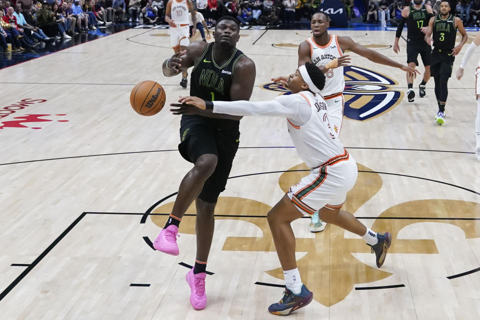 New Orleans Pelicans forward Zion Williamson (1) is stripped of the ball as he drives to the basket against San Antonio Spurs forward Keldon Johnson (3) in the second half of an NBA basketball game in New Orleans, Friday, Dec. 1, 2023. The Pelicans won 121-106. (AP Photo/Gerald Herbert)