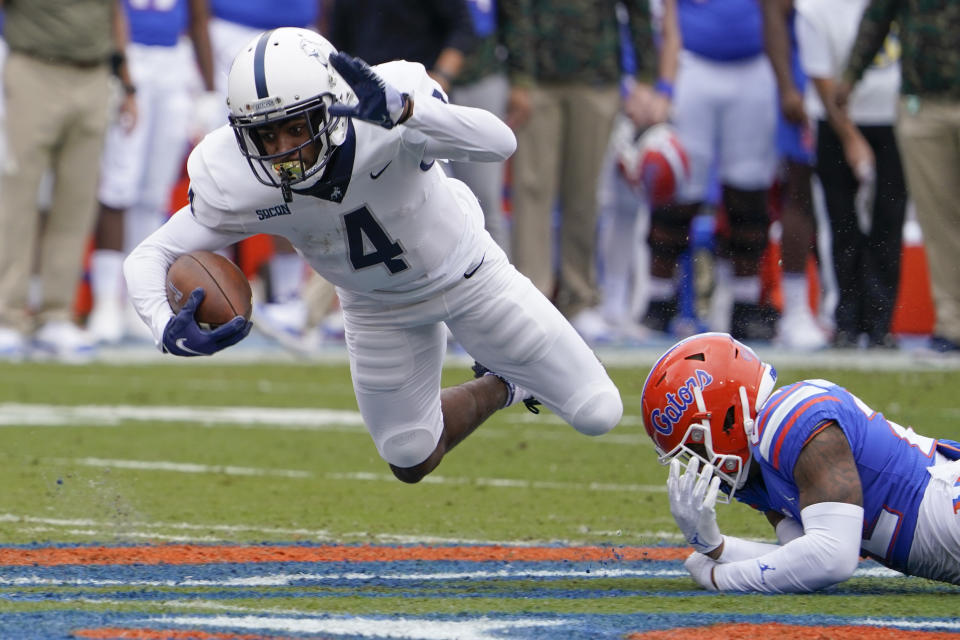 FILE - Samford wide receiver Montrell Washington (4) is tripped up by Florida safety Rashad Torrence II after a reception in the first half of an NCAA college football game on Nov. 13, 2021, in Gainesville, Fla. The Denver Broncos added another offensive weapon for Russell Wilson by taking speedy returner/receiver Montrell Washington in the fifth round of the NFL draft, Saturday, April 30, 2022. (AP Photo/John Raoux, File)