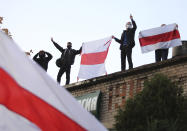 People hold up old Belarusian flags as they attend an opposition rally to protest the official presidential election results in Minsk, Belarus, Sunday, Oct. 25, 2020. The demonstrations were triggered by official results giving President Alexander Lukashenko 80% of the vote in the Aug. 9 election that the opposition insists was rigged. Lukashenko, who has ruled Belarus with an iron fist since 1994, has accused the United States and its allies of fomenting unrest in the ex-Soviet country. (AP Photo)