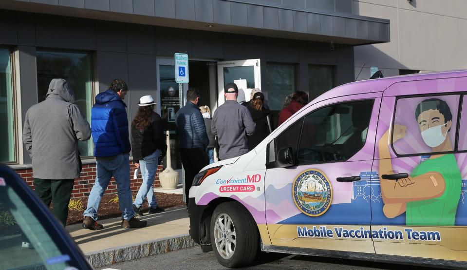 People line up at the New Hampshire Department of Health and Human Services building at Pease Tradeport, where the state's Mobile Vaccination Team holds a COVID-19 vaccine clinic Tuesday, Nov. 30, 2021.