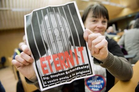 A woman holds a poster reading "Stephan Schmidheiny your place is in prison" in the courthouse during a trial against the Swiss firm Eternit's Italian plant in Turin February 13, 2012. REUTERS/Giorgio Perottino