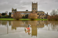 Children's playground equipment pokes out from floodwater surrounding Tewkesbury Abbey, where flood watches are in place with more wet weather expected in the coming days.