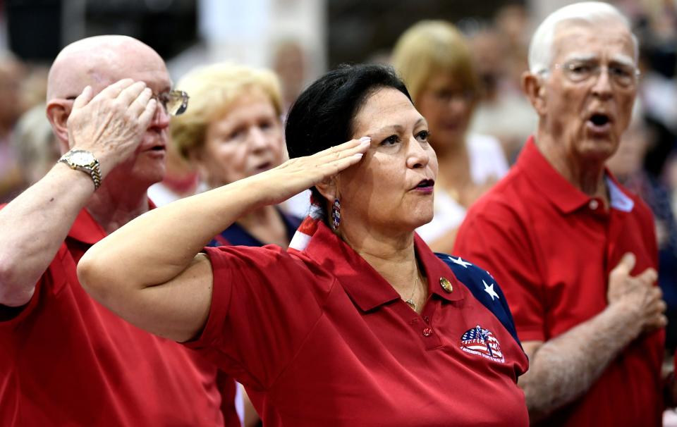 Cindy Vaillancourt, 34 years retired Air Force, saluting during the national anthem during Saturday's Sarasota County Republican Candidates annual "Pie Rally" held at Robarts Arena in Sarasota.