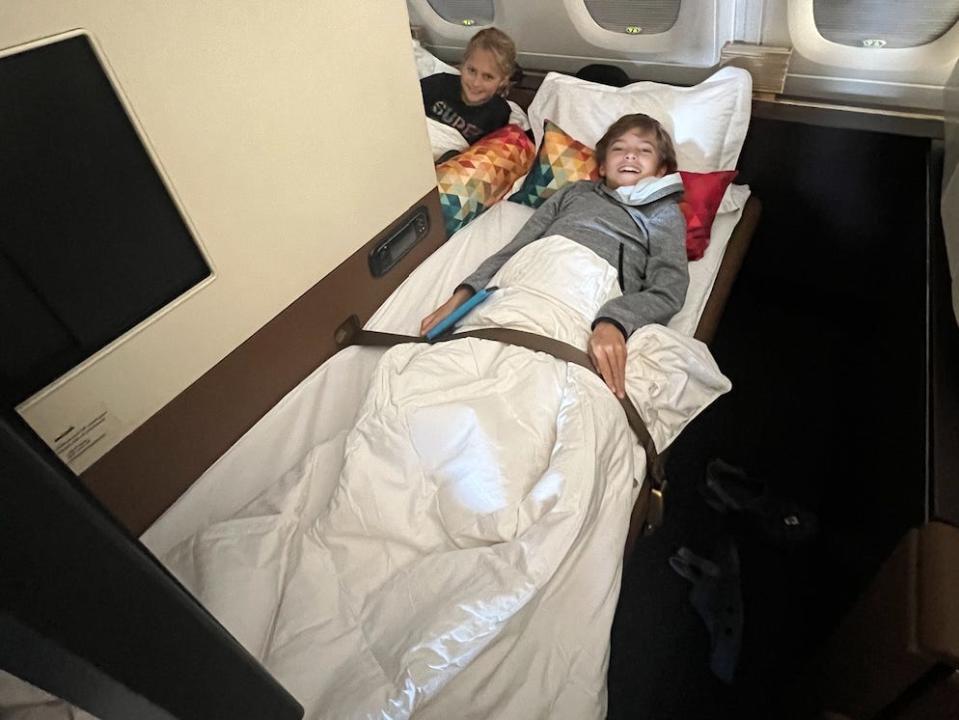 kids laying down in first-class on an airplane