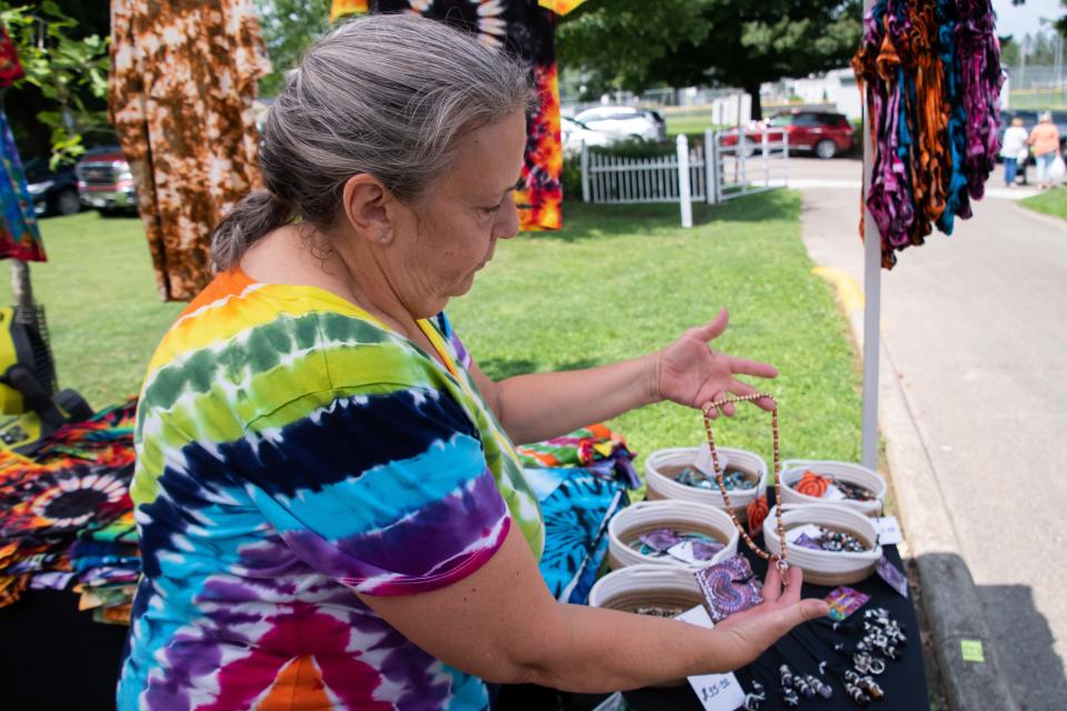 Amy Dru Beard displays some of her handcrafted necklaces at the Salt Fork Arts and Craft Festival at Cambridge City Park. She began making the pieces during COVID and now travels to festivals throughout the state selling her art.