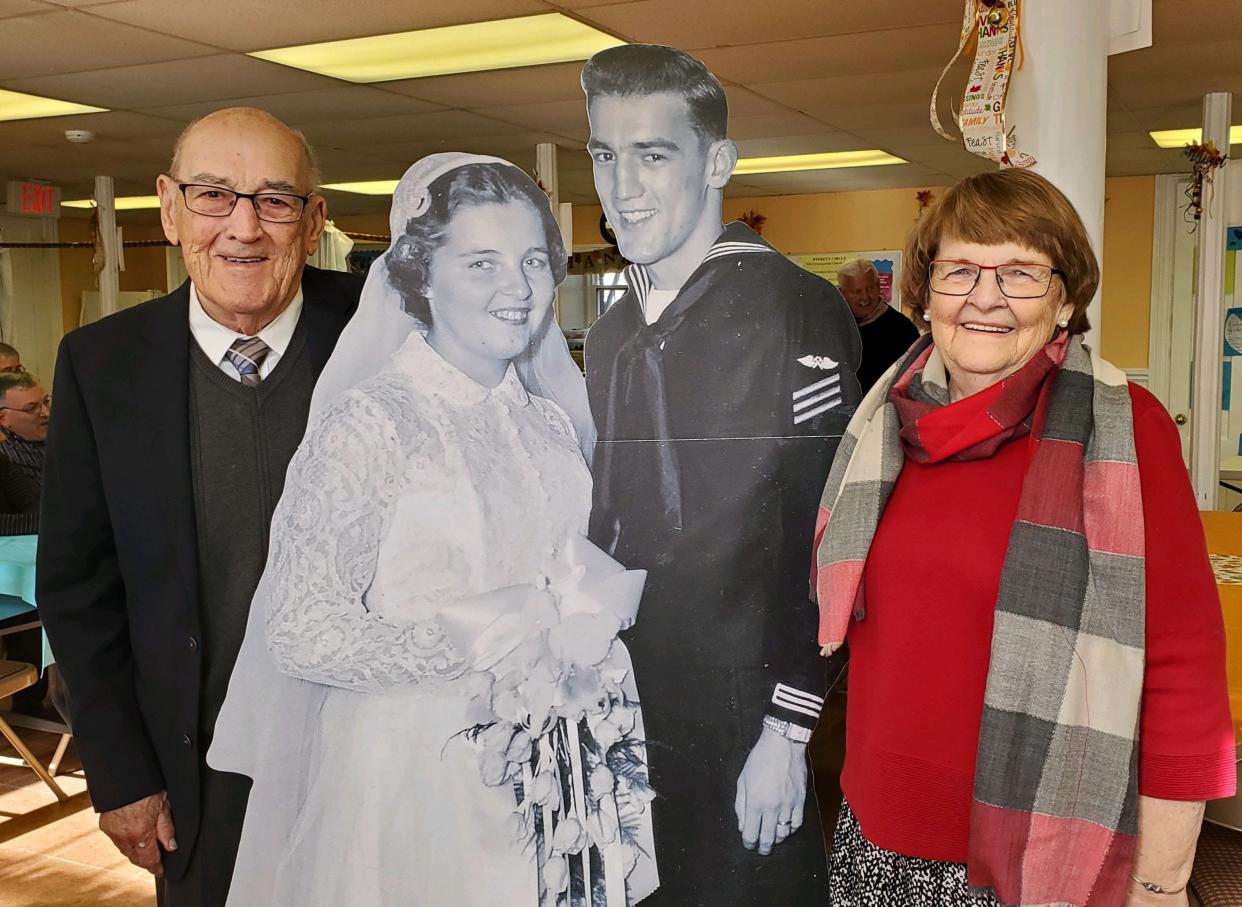 Roger and Myrtle Bacon pose with life-size replicas of their wedding photo, an anniversary gift from their daughters.