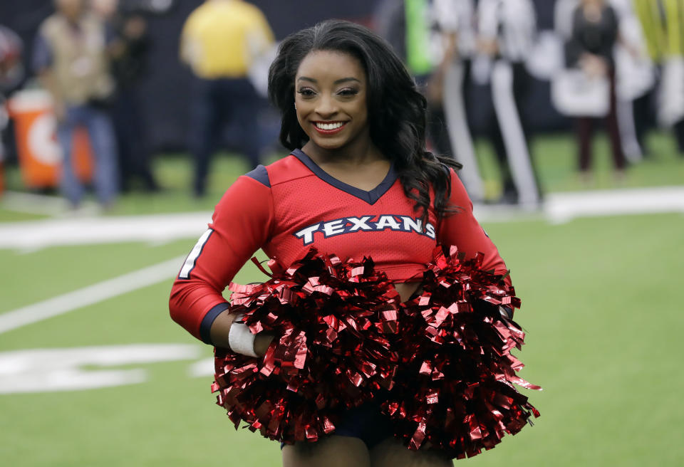 Honorary cheerleader Simone Biles stands on the field before the Houston Texans and San Francisco 49ers game. (AP)