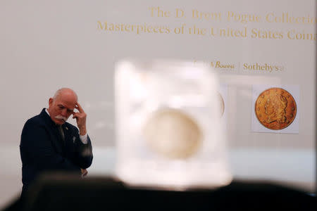 A security guard stands behind the Sultan of Muscat-Brands-Childs 1804 Silver Dollar which is displayed as part of the D. Brent Pogue collection to be sold on Tuesday at Sotheby's in New York, U.S., May 24, 2016. REUTERS/Lucas Jackson