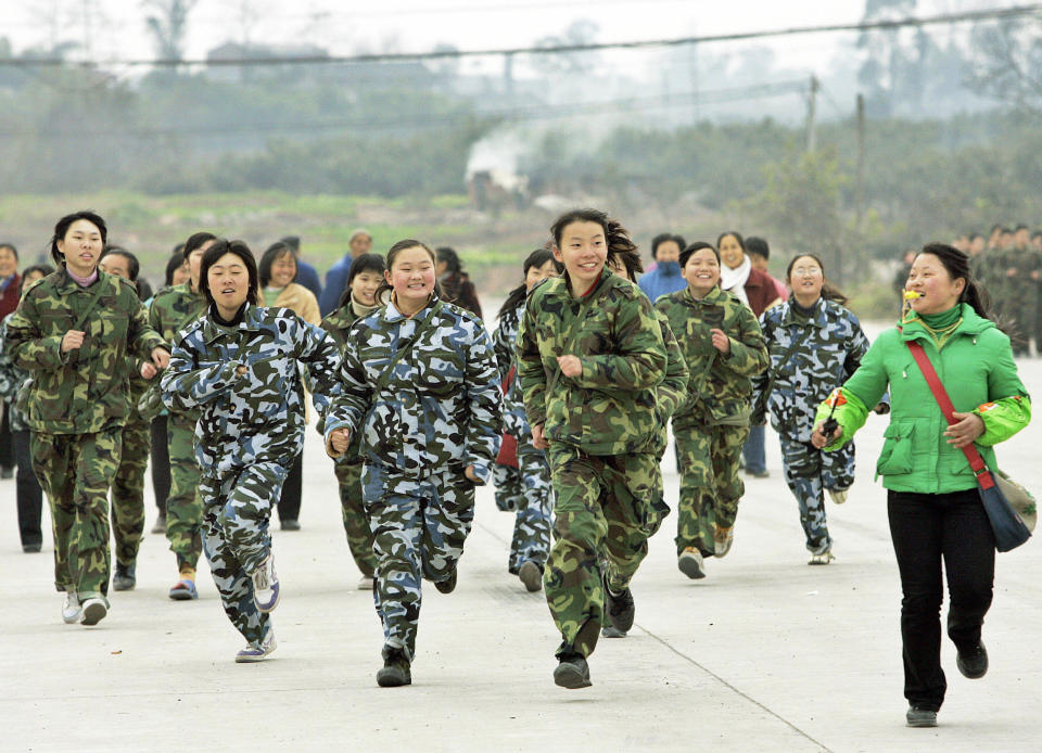 A class of students run during a physical training exercise at the temporary campus of the "Walking School" of Xu Xiangyang Education and Training Group on December 22, 2005, on the outskirts of China's southwestern city of Chengdu. 