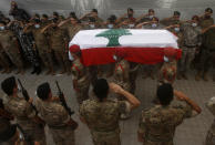 Lebanese army soldiers carry the coffin of lieutenant Ayman Noureddine, who was killed by Tuesday's explosion that hit the seaport of Beirut, during his funeral procession, in Numeiriyeh village, south Lebanon, Friday, Aug. 7, 2020. Rescue teams were still searching the rubble of Beirut's port for bodies on Friday, nearly three days after a massive explosion sent a wave of destruction through Lebanon's capital. (AP Photo/Mohammed Zaatari)