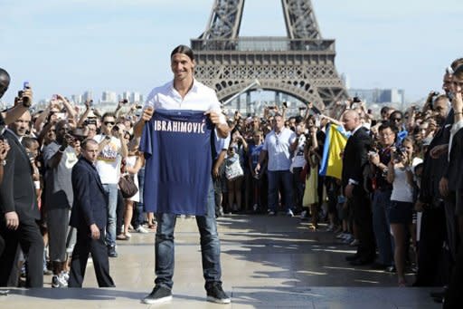 Paris Saint-Germain (PSG) football club's newly recruited Sweden striker Zlatan Ibrahimovic poses with his shirt in front of the Eiffel tower in Paris. Ibrahimovic greeted fans of his new club Paris Saint-Germain in an ostentatious presentation ceremony in front of the Eiffel Tower in Paris on Wednesday