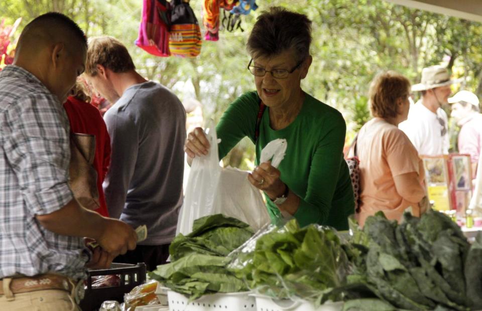 This May 28, 2013 photo shows a woman buying organic vegetables products in a market setting in Boquete, west of Panama City, Panama. Panama has become a hot spot for American retirees. They come for the natural beauty, the weather and, perhaps more important, the low cost of living. (AP Photo/Arnulfo Franco)