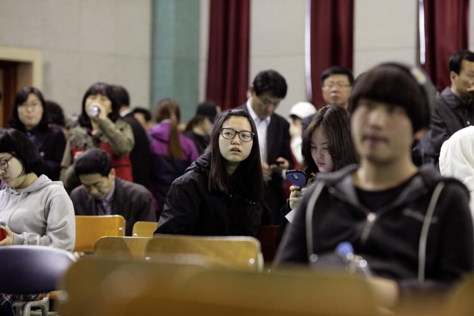 Students watch the news screen which shows a sinking vessel at an auditorium at Danwon High School in Ansan, South Korea, Thursday, April 17, 2014. Strong currents, rain and bad visibility hampered an increasingly anxious search Thursday for 287 passengers, including many students from the high school for a four-day trip, still missing a day after their ferry flipped onto its side and sank in cold waters off the southern coast of South Korea. (AP Photo/Woohae Cho)