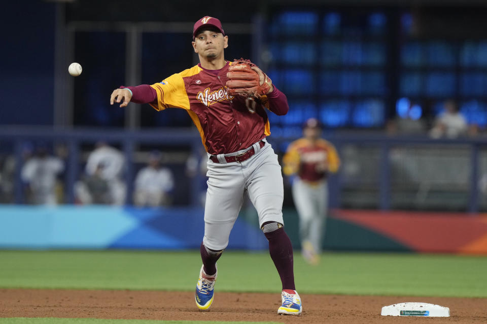 Venezuela short stop Andres Gimenez (0) throws to first to complete a double play during the a World Baseball Classic game against Israel, Wednesday, March 15, 2023, in Miami. (AP Photo/Marta Lavandier)