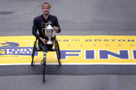 Marcel Hug of Switzerland holds the trophy after winning the men's wheelchair division at the Boston Marathon, Monday, April 15, 2024, in Boston. (AP Photo/Charles Krupa)