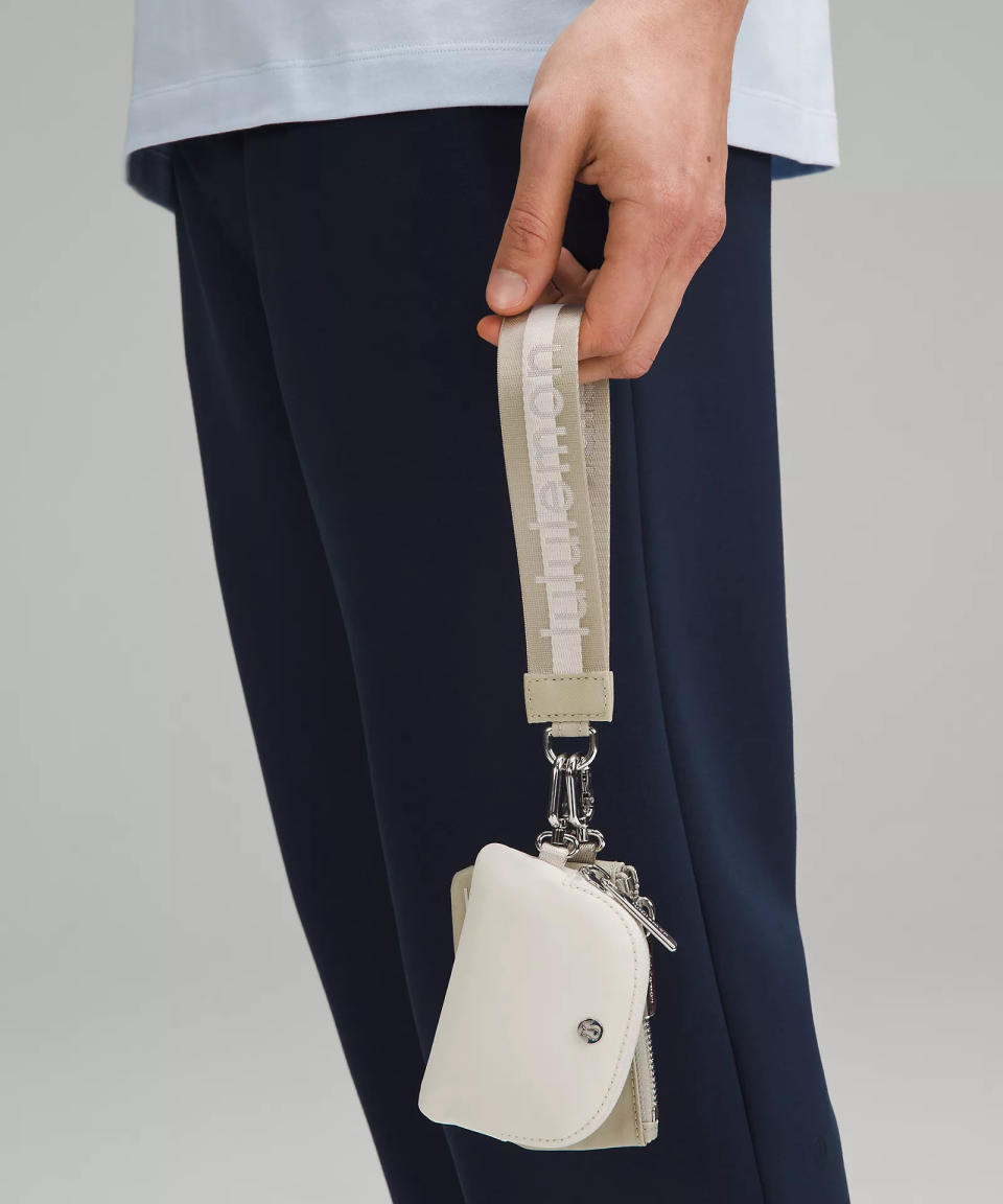 someone holding the Dual Pouch Wristlet Wordmark