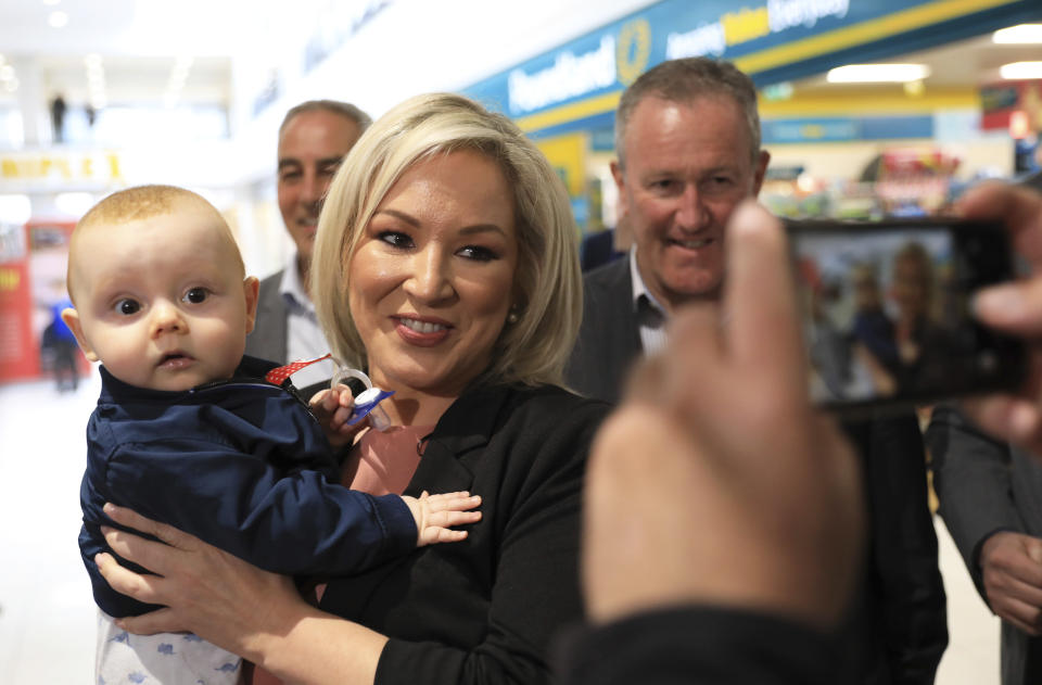 Michelle O'Neill, Sinn Fein leader in Northern Ireland, holds Setanta Maguibhir while out canvassing in West Belfast, Northern Ireland, Tuesday, May 3, 2022. The Sinn Fein election team were out election campaigning ahead of Thursdays local election. Sinn Fein, a force in Irish republicanism on both sides of the Irish border looks likely to become the largest party in the assembly, according to polls ahead of the May 5, 2022 local elections. (AP Photo/Peter Morrison)