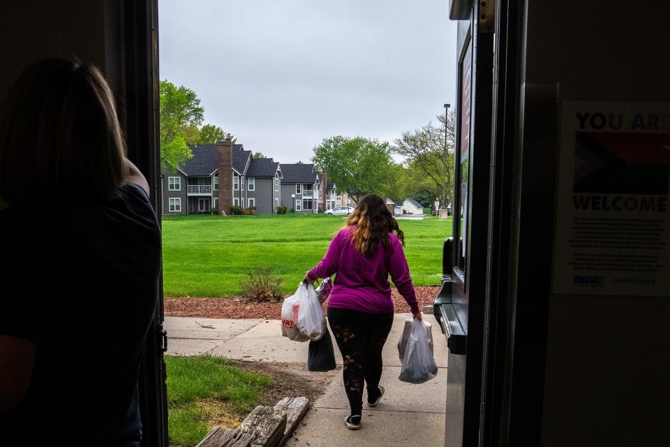 A woman leaves the Johnston Food Pantry with bags of food, on Tuesday, May 9, 2023, in Johnston. 