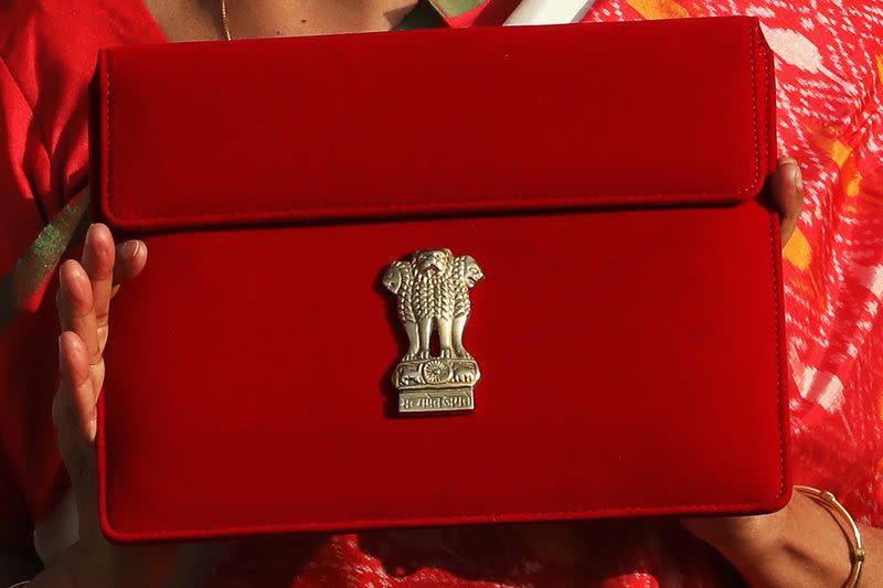 India's Finance Minister Nirmala Sitharaman holds up a folder with the Government of India logo, as she leaves her office to present the federal budget in the parliament in New Delhi