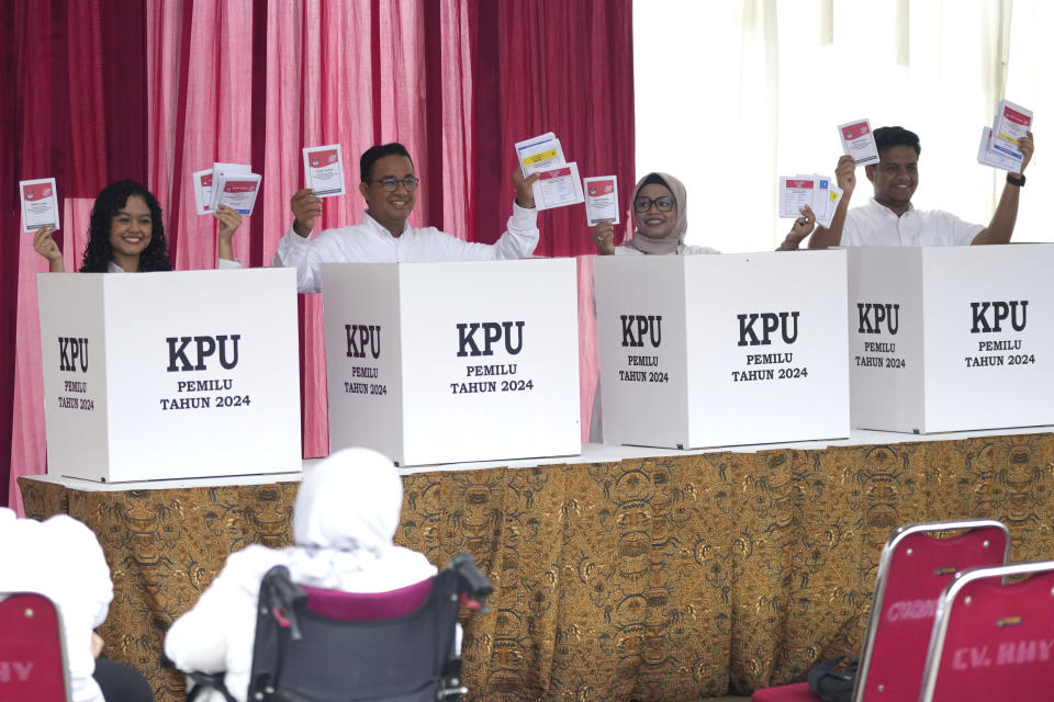 Presidential candidate Anies Baswedan, second left, and his family, from left, daughter Mutiara Annisa, wife Fery Farhati and son Mikail Azizi show their ballots during the election in Jakarta, Indonesia, Wednesday, Feb. 14, 2024. Indonesian voters were choosing a new president Wednesday as the world's third-largest democracy aspires to become a global economic powerhouse a quarter-century after shaking off a brutal dictatorship. (AP Photo/Tatan Syuflana)