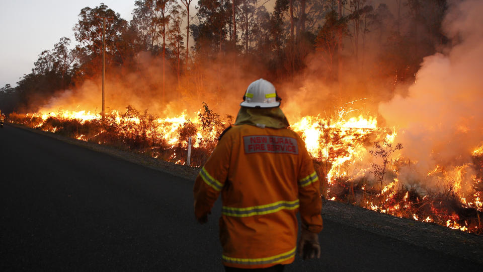 An RFS crewman watches a back burn along Aerodrome road, Nabiac , Sunday, October 27, 2019. Almost 1200 firefighters are tackling large bushfires on the NSW mid-north coast among scores of blazes around the state. (AAP Image/Darren Pateman) NO ARCHIVING