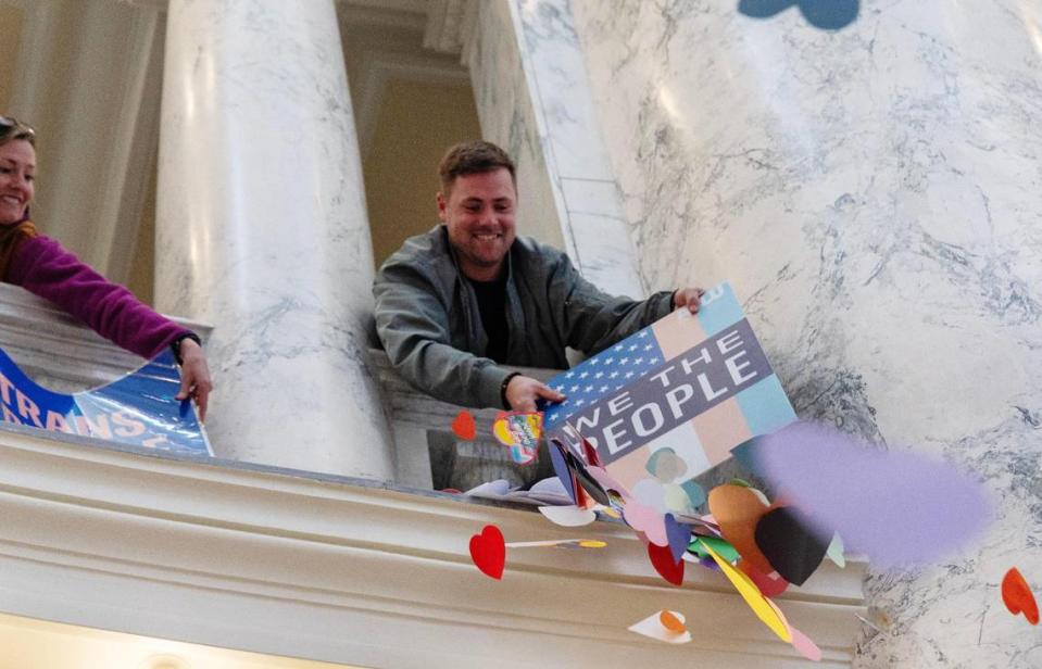 Logan Self of Boise uses a transgender rights sign to knock paper hearts off of a ledge of the Idaho Capitol rotunda during a demonstration, Tuesday, April 2, 2024. Sarah A. Miller/smiller@idahostatesman.com