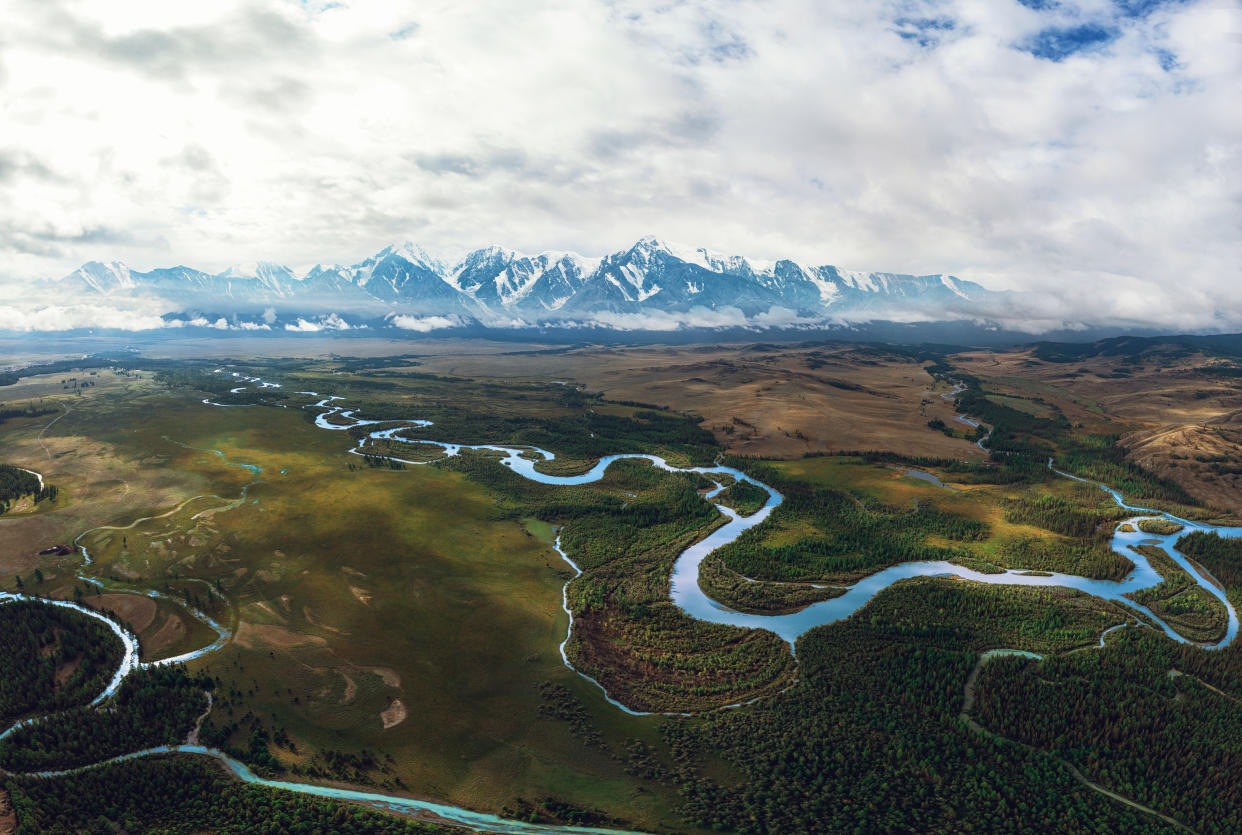 Kurai steppe and Chuya river on North-Chui ridge background. Altai mountains, Russia. Aerial drone panoramic picture.