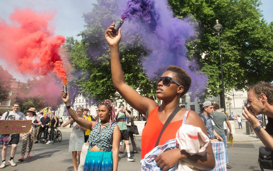 Protesters carry smoke flares - Credit:  Nick Edwards