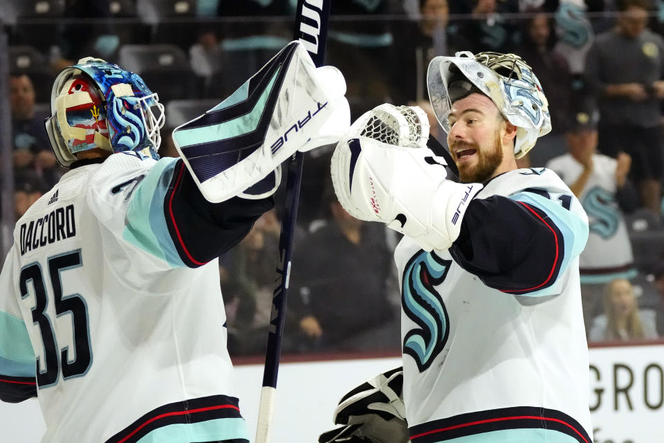 Seattle Kraken goaltender Joey Daccord (35), a former Arizona State hockey player, celebrates a win against the Arizona Coyotes with Kraken goaltender Philipp Grubauer, right, during the third period of an NHL hockey game Monday, April 10, 2023, in Tempe, Ariz. The Kraken won 4-1. (AP Photo/Ross D. Franklin)