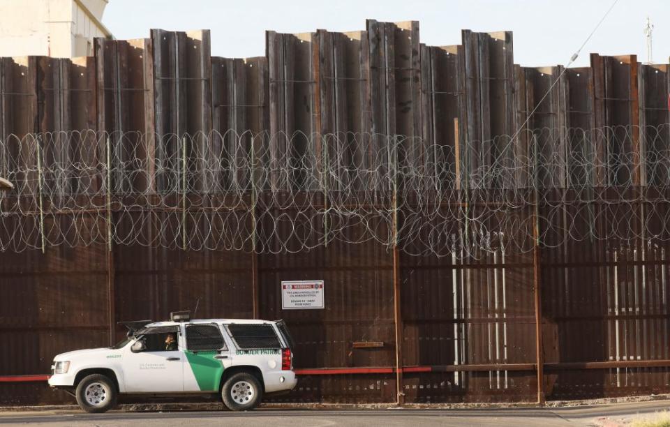 A Border Patrol agent is posted in front of the U.S.-Mexico border barrier in Imperial County, which has been hard-hit by the COVID-19 pandemic, on July 24, 2020 in Calexico, California. (Photo by Mario Tama/Getty Images)