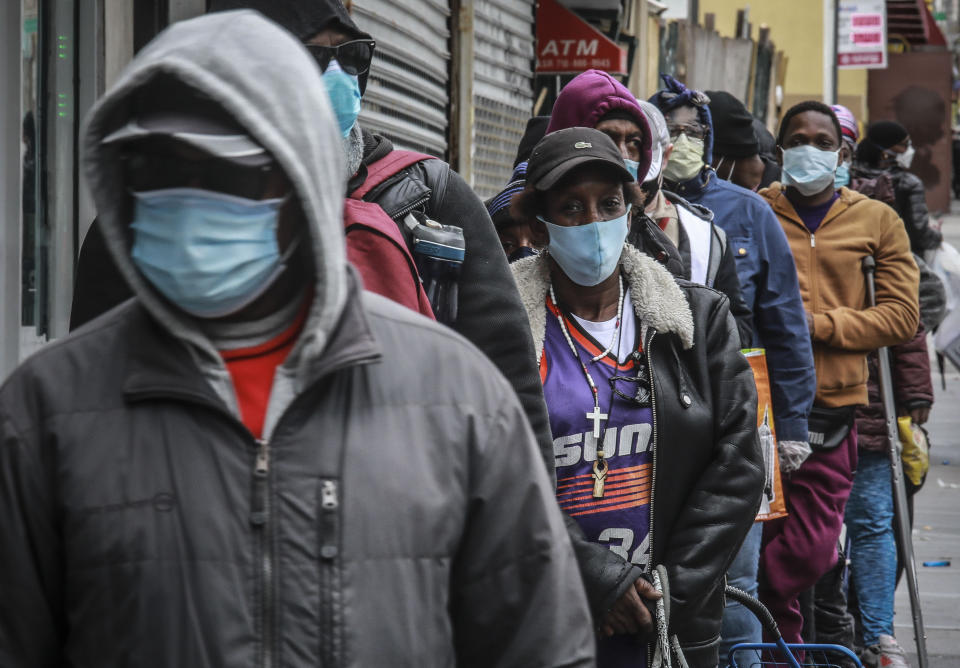 FILE - In this April 18, 2020, file photo, people wait for a distribution of masks and food from the Rev. Al Sharpton in the Harlem neighborhood of New York. Black people are facing a combination of stressors hitting simultaneously: isolation during the pandemic, a shortage of mental health care providers and racial trauma inflicted by repeated police killings of Black people. Black people suffer disproportionately from COVID-19 and have seen soaring rates in youth suicide attempts. ( (AP Photo/Bebeto Matthews, File)