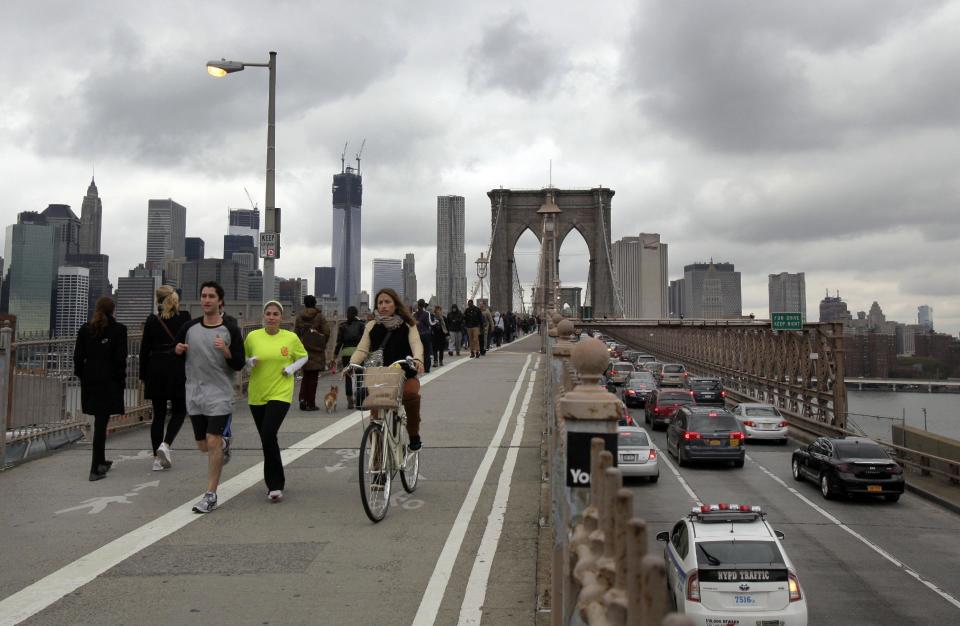 Commuters cross New York's Brooklyn Bridge, Wednesday, Oct. 31, 2012. Morning rush-hour traffic appeared heavier than on an ordinary day as people started to return to work in a New York without functioning subways. Cars were bumper to bumper on several major highways. (AP Photo/Richard Drew)