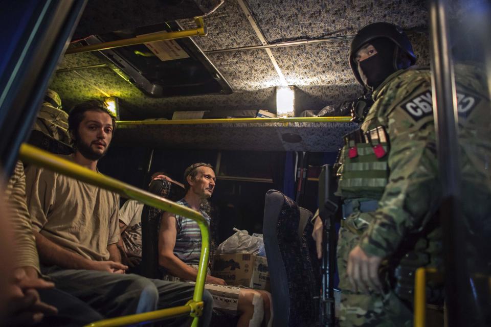 Members of the pro-Russian rebels, who are prisoners-of-war, sit in a bus as they wait to be exchanged, north of Donetsk, eastern Ukraine