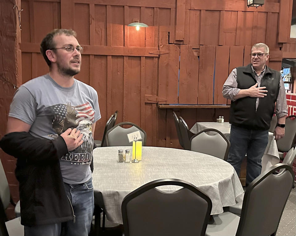 Congressional candidate Darren Bailey, right, leads the Pledge of Allegiance at a campaign stop with the help of Casey resident Brandon Baston and his American flag T-shirt, Tuesday, Feb. 27, 2024 in Casey, ill. Bailey, a former state senator and 2022 Republican nominee for governor, is running in the March 19th primary to unseat fellow GOP Congressman Mike Bost, a five-term incumbent who has the endorsement of former President Donald Trump, in Illinois' 12th District, which encompasses the bottom one-third of Illinois. (AP Photo/John O'Connor)