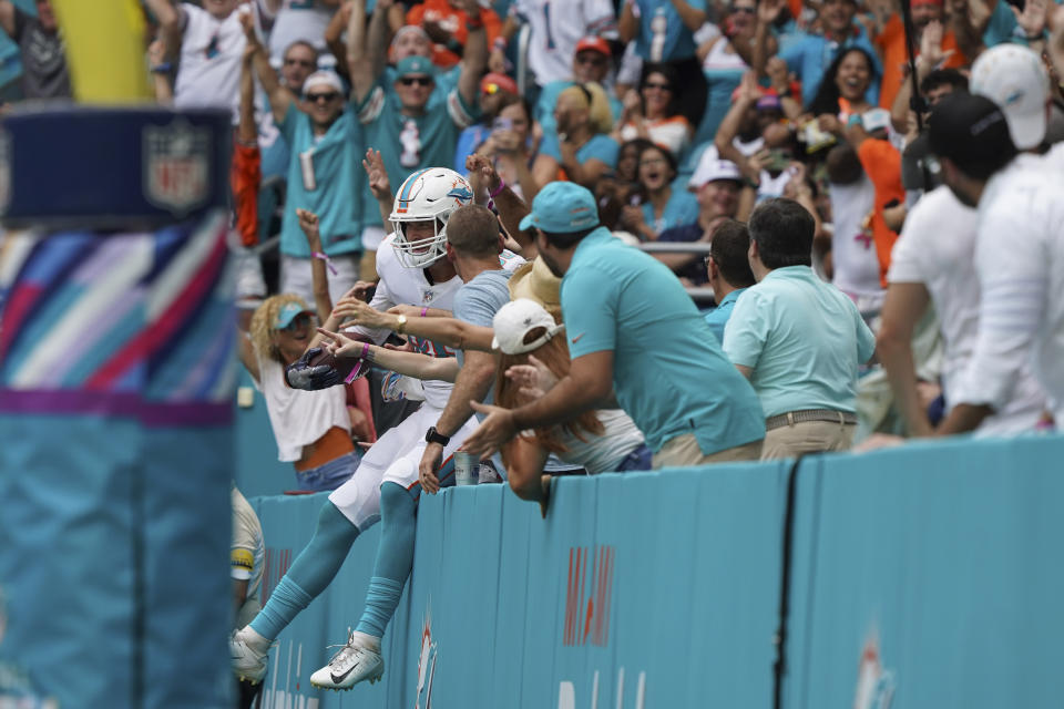 Miami Dolphins tight end Mike Gesicki (88) jumps into the stands as he celebrates after scoring a touchdown during the second half of an NFL football game against the Atlanta Falcons, Sunday, Oct. 24, 2021, in Miami Gardens, Fla. (AP Photo/Hans Deryk)